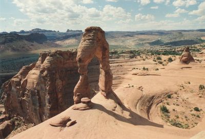 Man standing on rock formation against clear sky