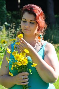 Close-up of woman with red flower