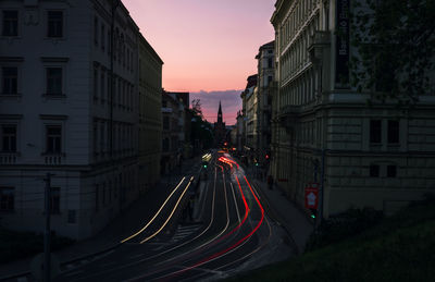 Light trails on road against sky at sunset