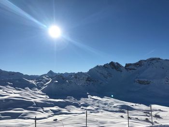 Scenic view of snowcapped mountains against clear blue sky