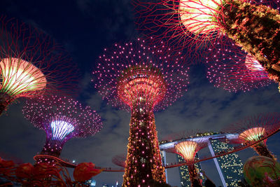 Low angle view of illuminated carousel against sky at night
