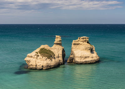 Rocks in sea against sky