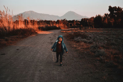 Full length portrait of man walking on road