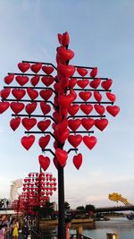 Red lanterns hanging by building against sky