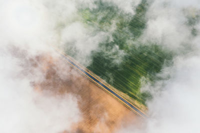 High flight in the cumulus clouds over agricultural fields in summer.