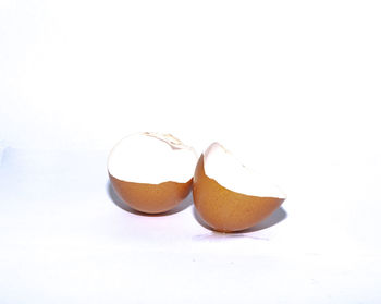 Close-up of broken egg against white background