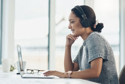 Businesswoman with braces on video call though laptop in office