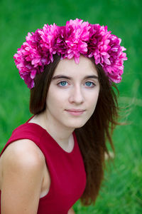 Close-up portrait of beautiful woman with pink flower