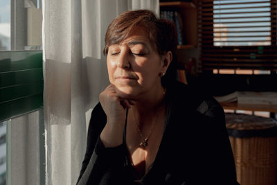 Portrait of young woman sitting at home