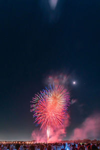 Low angle view of firework display in sky at night