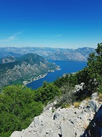 Scenic view of sea and mountains against blue sky