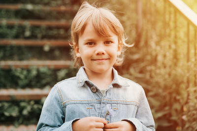 Portrait of the face of a cute happy smiling little five year old long blond caucasian kid boy