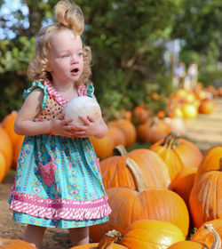 Girl holding pumpkin at park during autumn