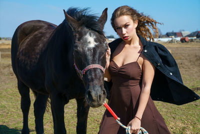 Close-up of woman with horse on field