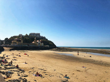 People on beach against clear sky