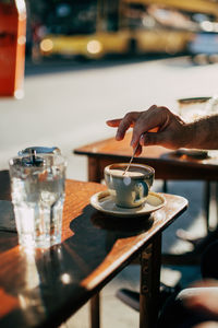 Male hand stirring coffee at a coffee shop