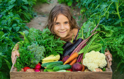 Portrait of young woman with vegetables for sale in market