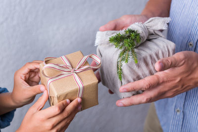 Midsection of people holding gifts in hand