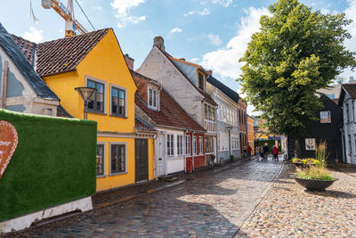 Street amidst houses and buildings against sky