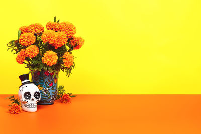 Close-up of flower vase against orange background