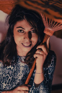 Portrait of smiling young woman holding camera