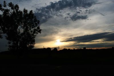 Silhouette trees on landscape against sky during sunset