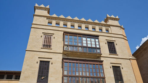 Low angle view of old building against clear blue sky