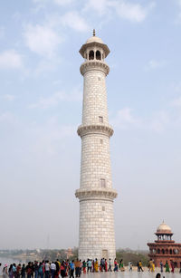 People in front of tower against sky