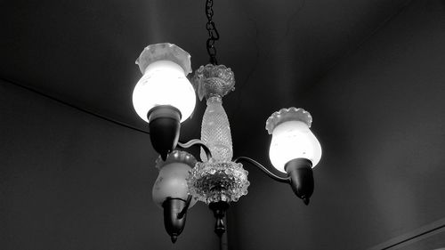 Low angle view of illuminated pendant light hanging from ceiling