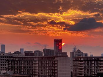 Buildings in city against sky during sunset