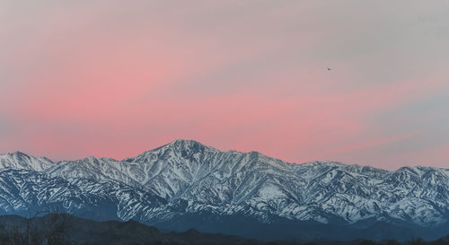 View of the snowy mountain range in the andes with the first lights of