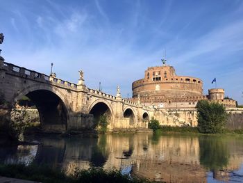 Arch bridge over river against sky