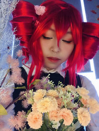 Close-up portrait of woman with red flowers