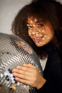 Portrait of smiling woman by disco ball