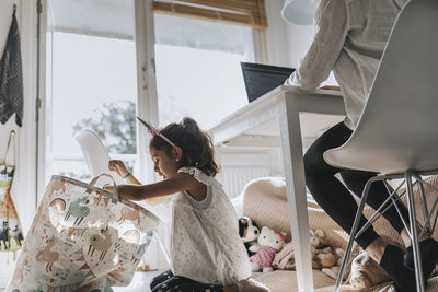 Girl playing while her mother working