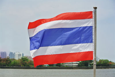 Close-up national flag of thailand against river scenery background