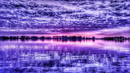 Scenic shot of calm lake against cloudy sky