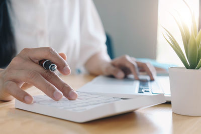 Midsection of man using laptop on table