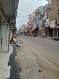 Street amidst buildings against sky in city