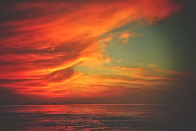 Scenic view of sea against dramatic sky during sunset