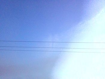 Low angle view of vapor trail against clear blue sky