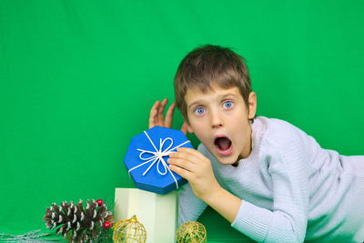 Portrait of boy against green background