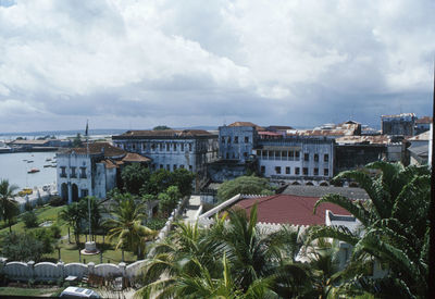 Buildings in town against cloudy sky