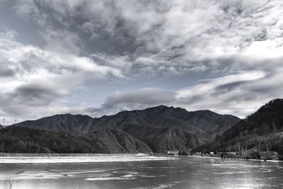 Scenic view of sea and mountains against sky