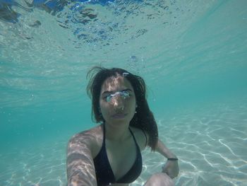 Portrait of woman swimming underwater