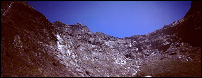 Scenic view of rocky mountains against clear blue sky