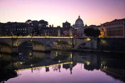 Reflection of bridge over river in city of rome