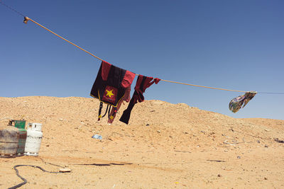 Clothes drying on rope against clear sky