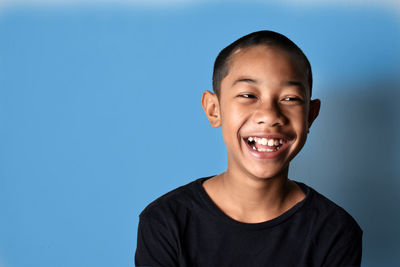 Portrait of smiling boy against blue background