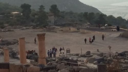 Group of people on mountain road against sky